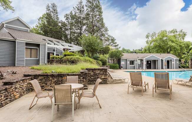 A backyard with a pool and patio furniture.