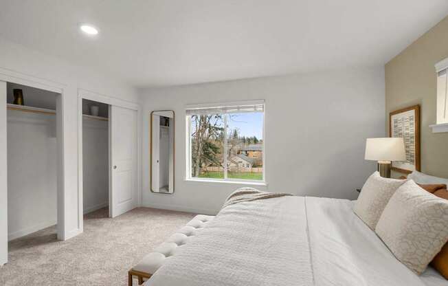 a white bedroom with a large bed and a window