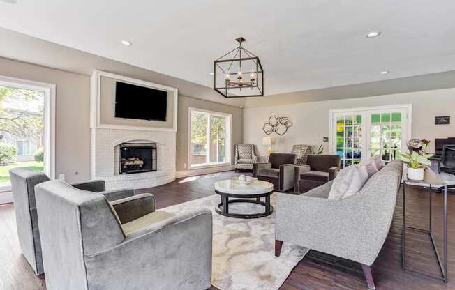 Apartments in Geneva, IL for Rent- Ashford at Geneva- A modern living room with a grey sofa and a fireplace.