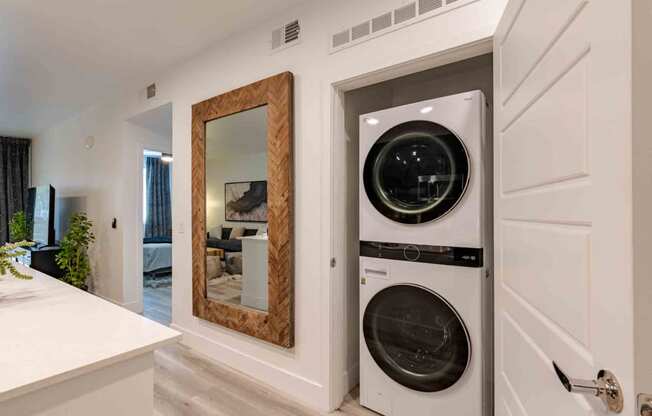 laundry room with a washer and dryer and a large mirror