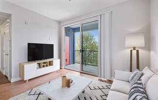 a living room with a couch and a tv and a balcony