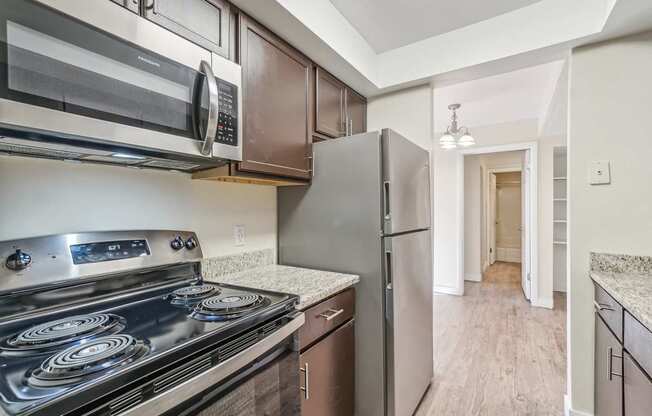 A kitchen with a stove, oven, microwave, and refrigerator.