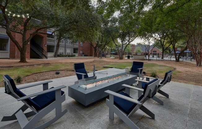 A fire pit surrounded by chairs in a courtyard.