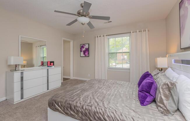 a bedroom with a purple blanket on a bed