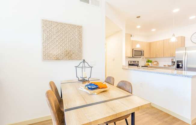 a dining room table with a kitchen in the background