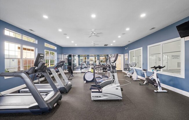 A spacious gym with treadmills, elliptical machines, and other exercise equipment.