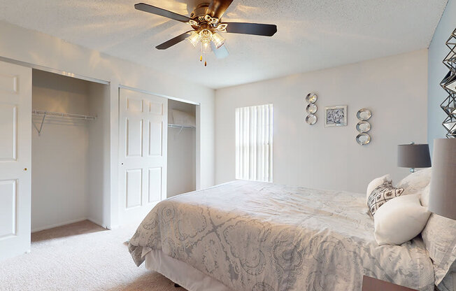 a bedroom with a bed and a ceiling fan