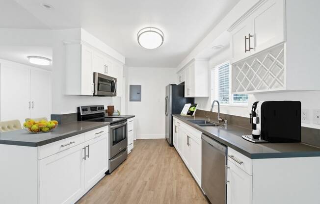 a kitchen with white cabinets and stainless steel appliances