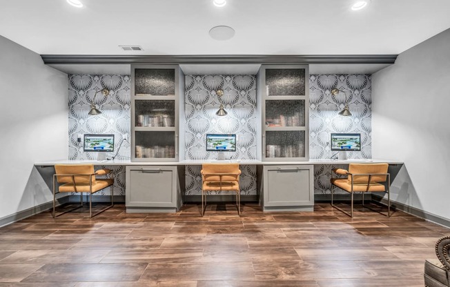 an office space with two desks and chairs and a counter with two computers