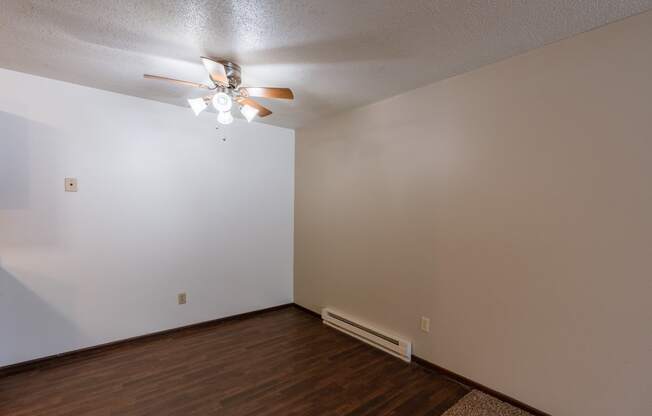 A dining room with a ceiling fan and wood floors. Fargo, ND Long Island Apartments.