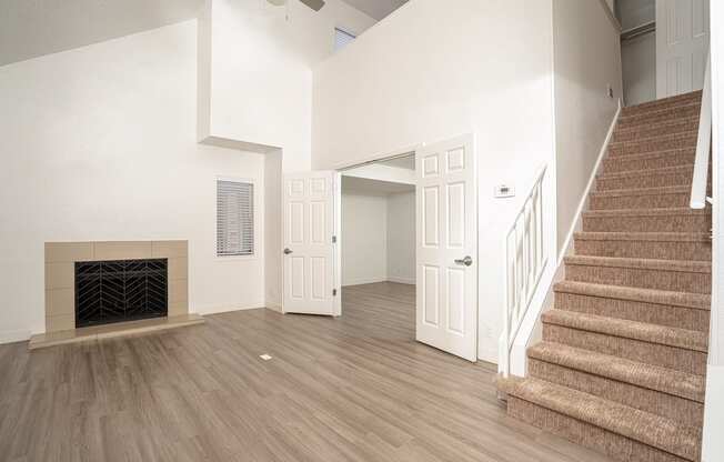 a living room with stairs and a fireplace