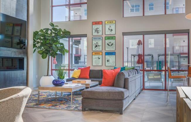 A living room with a couch, chair, and a potted plant.