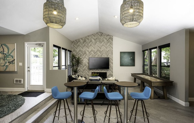 a room with a table and chairs and a tv on the wall