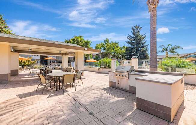 A patio with a table and chairs is surrounded by a brick wall.
