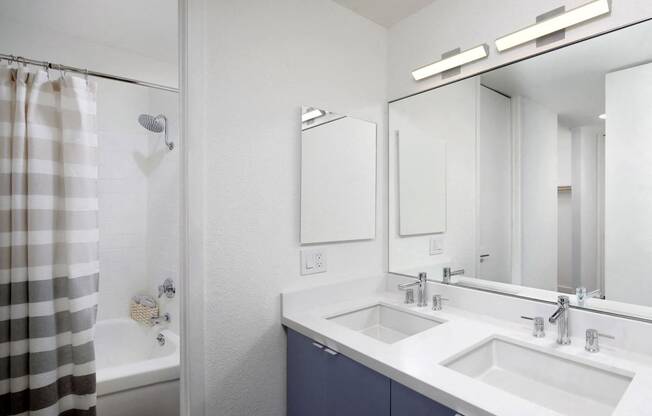 a bathroom with two sinks and a shower and a mirror