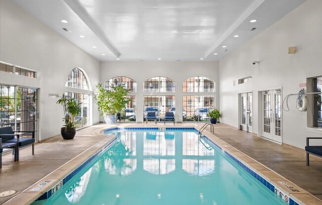 A large indoor swimming pool with a blue tiled edge.