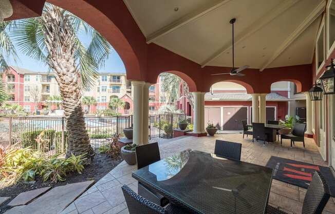 a patio with a table and chairs and a palm tree