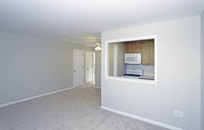 A white room with a window and a microwave.