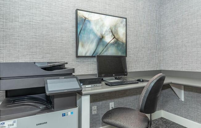 a desk with a laptop computer sitting on top of a chair