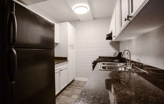 a kitchen with black appliances and white cabinets