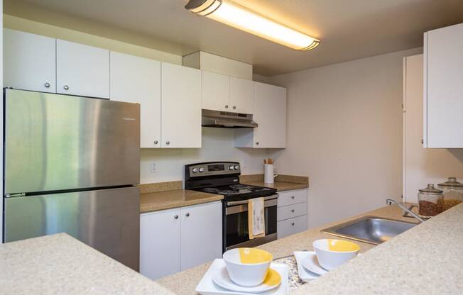 a kitchen with white cabinets and stainless steel appliances