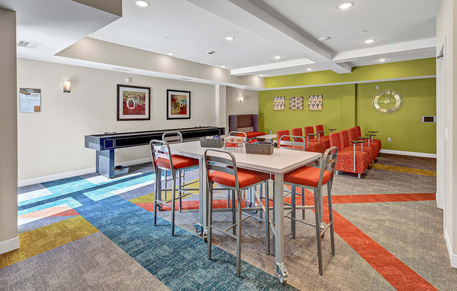 a community room with a table and chairs and a pool table