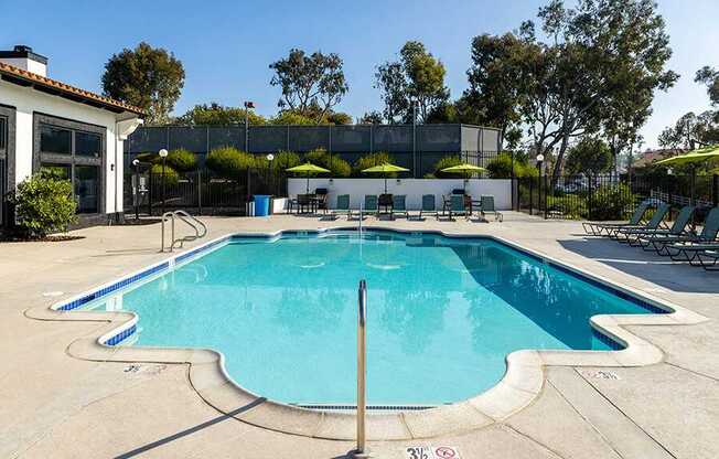 A large outdoor swimming pool with a diving board.