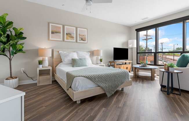 a bedroom with a bed and a tv in a room with hardwood floors