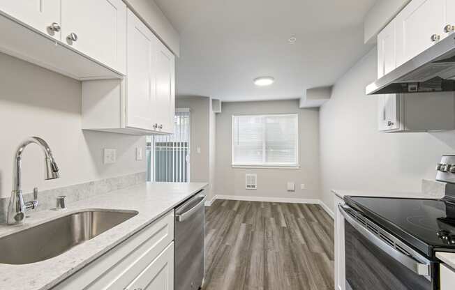 a kitchen with a sink and a stove and a window