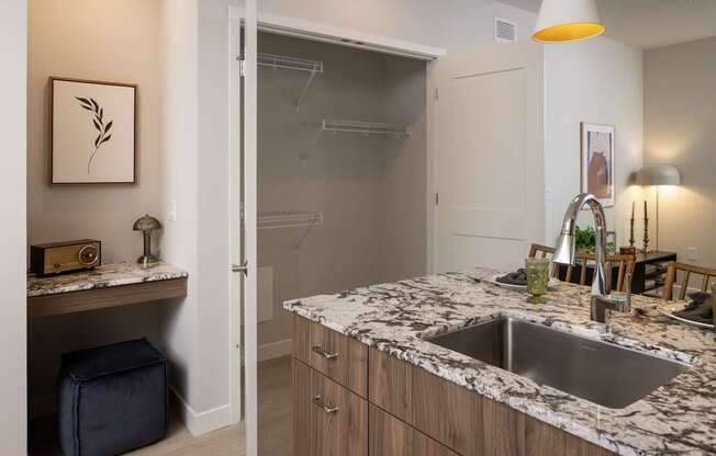 A kitchen with a marble countertop and a sink.