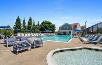 our resort style swimming pool is surrounded by lounge chairs and umbrellas