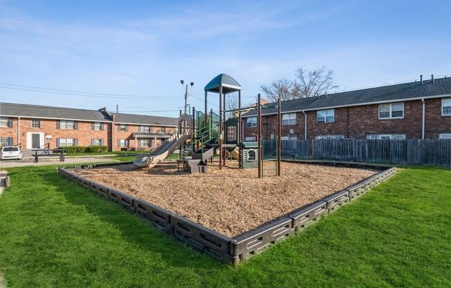 a playground with a swing set in the middle of a grassy area