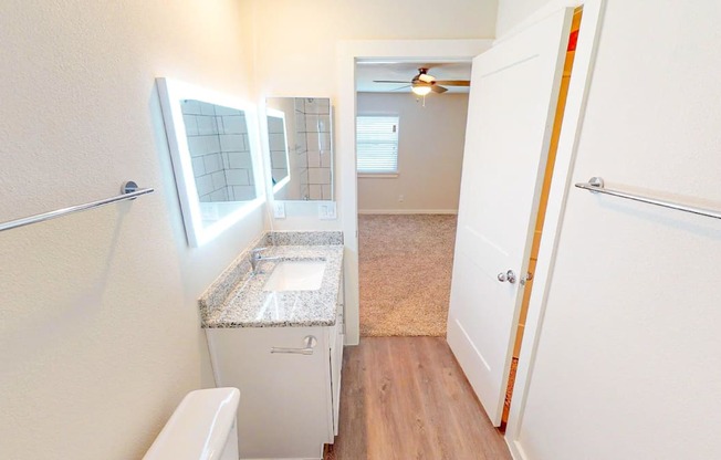 A small bathroom with a toilet, sink, and mirror.