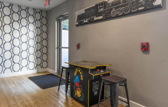 A room with a patterned wallpaper and a train picture on the wall.
