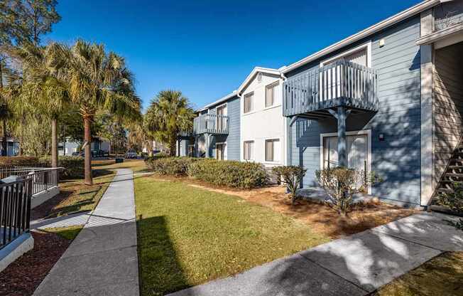 A sunny day at a residential area with apartment buildings and palm trees.
