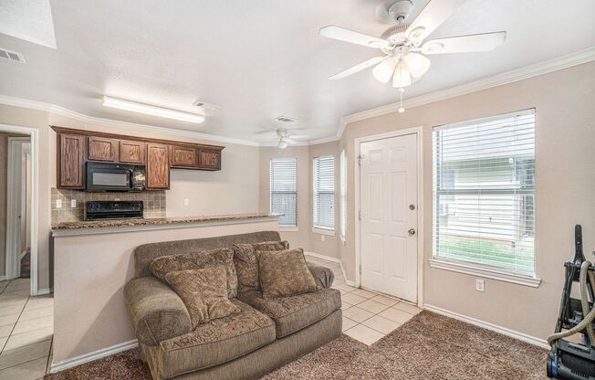 Beautiful two story townhome, crown molding, granite countertops, stained cabinets and carpeting in living area.