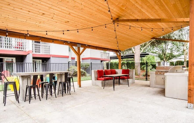 A wooden patio with a table and chairs under a roof. at Notch 8, Tacoma, Washington