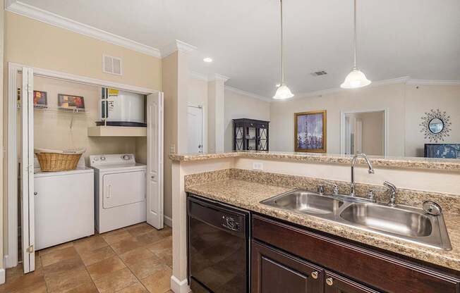A kitchen with a black dishwasher and a white washing machine.