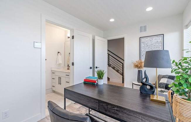 a home office with a desk and a door leading to a staircase