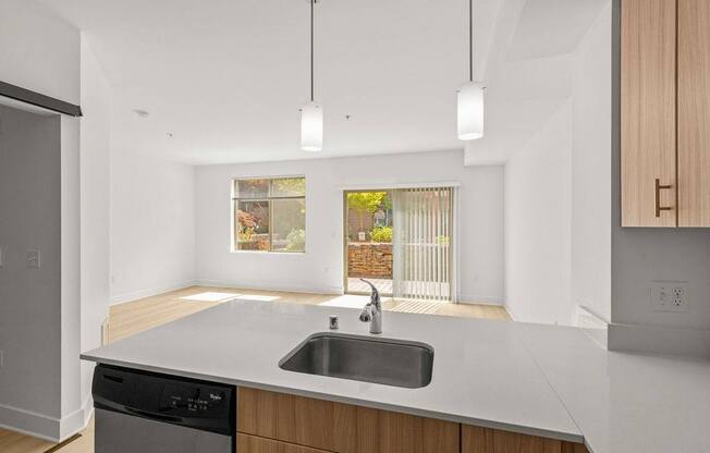A modern kitchen with a black dishwasher and a window.