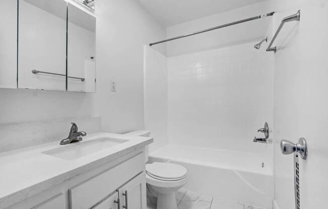 a white bathroom with a sink toilet and shower