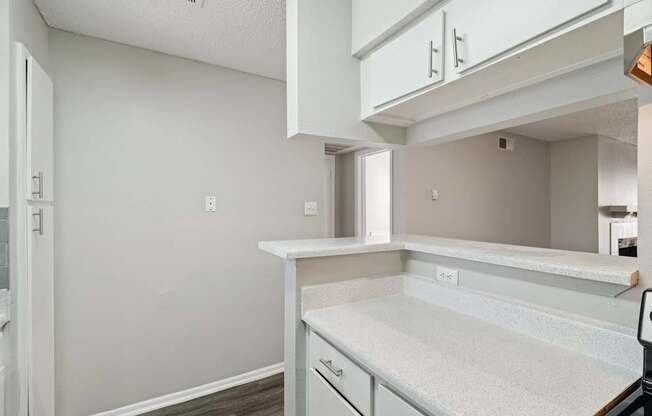 A kitchen with white cabinets and a white countertop.