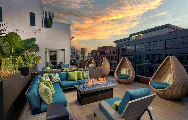 A modern outdoor seating area with a fire pit and comfortable chairs.