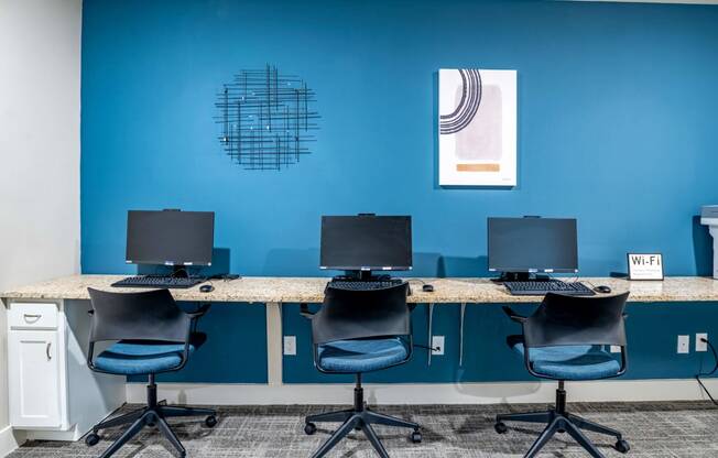 A row of three desktop computers and chairs at Trillium apartments in Melbourne fl