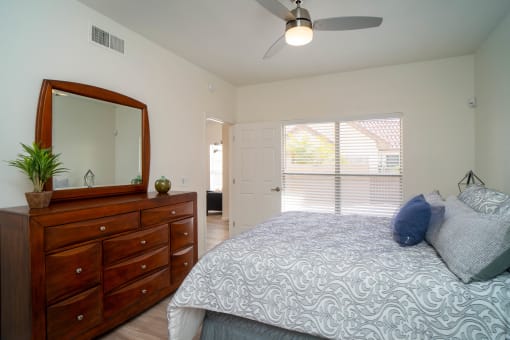 a bedroom with a large bed and a dresser with a mirror