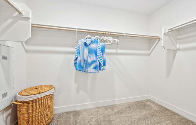 our spacious walk in closet is loaded with clothes and towels and has a large closet