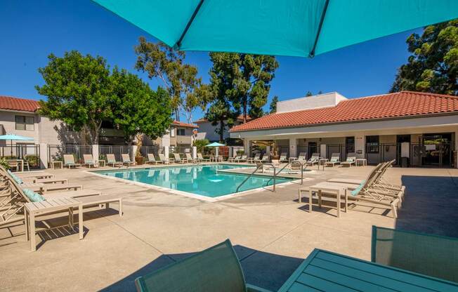 A sunny day at the pool with lounge chairs and umbrellas.