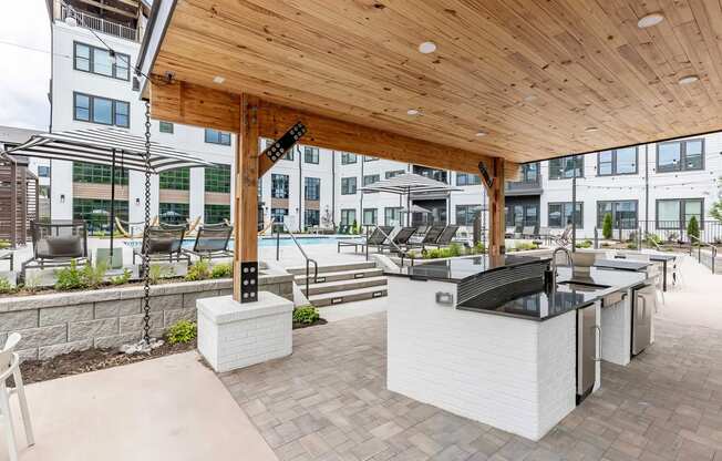 Full outdoor countertop with refrigerators under a modern pergola next to the pool at Novel Cary