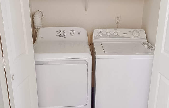 A small laundry room with a washer and dryer.