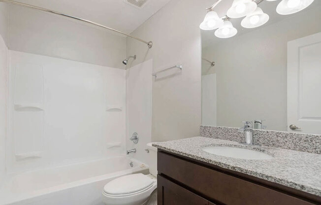 A white toilet sits next to a white sink in a bathroom.